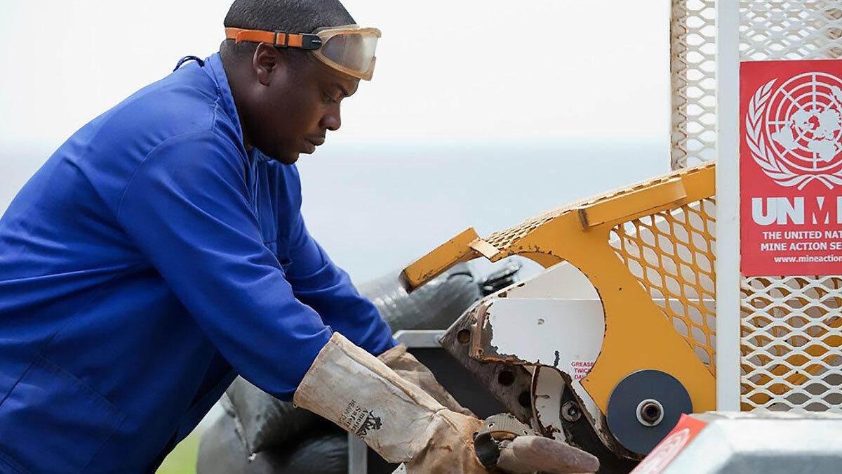 a man is destroying a weapon with a machine