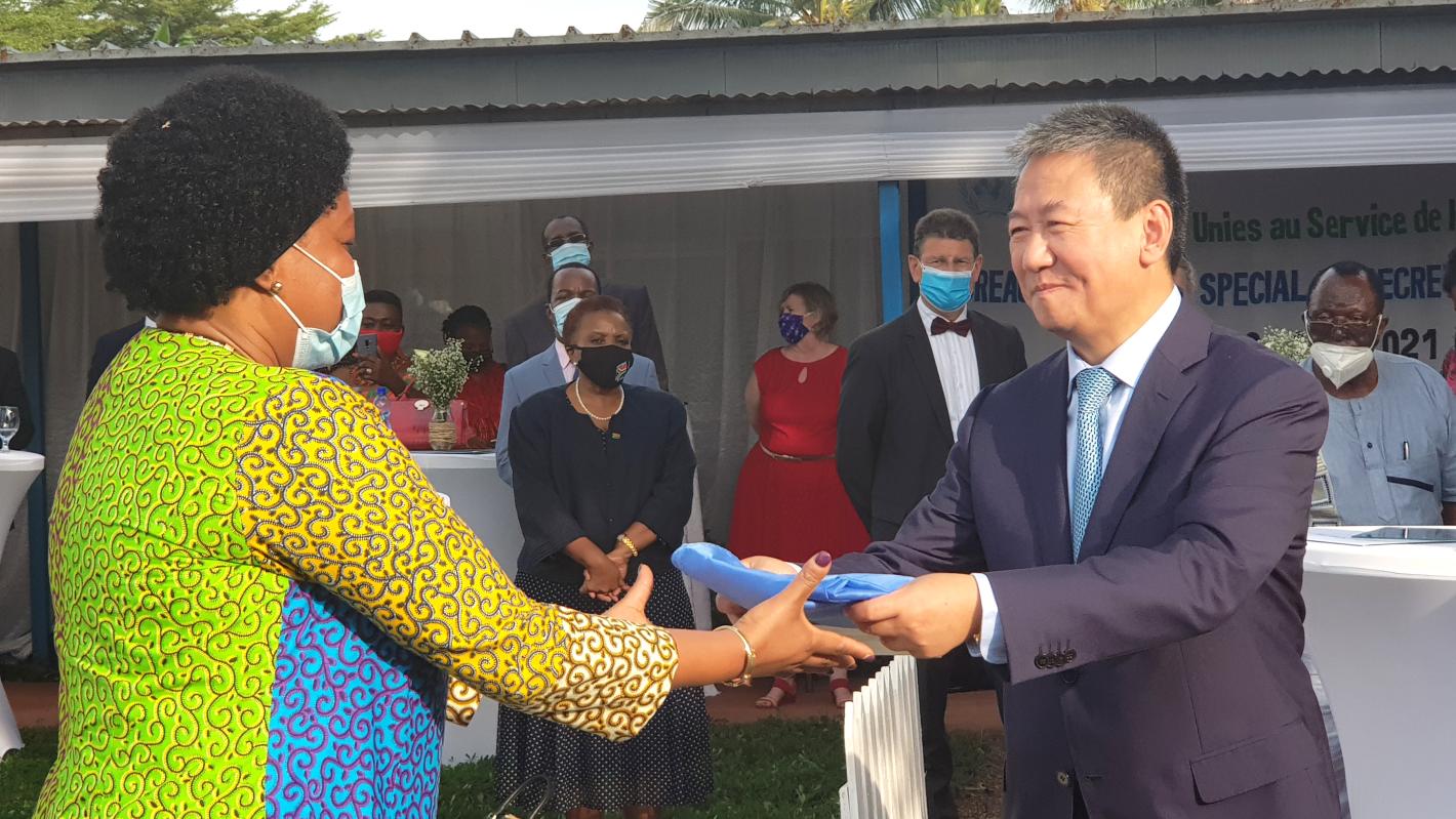 L'envoyé spécial pour les Grands Lacs Huang Xia remet le drapeau de l'ONU à l'OSESG-B à la coordonnatrice résidente par intérim, Nicole Kouassi, 31 mai 2021. ONU/Napoleon Viban