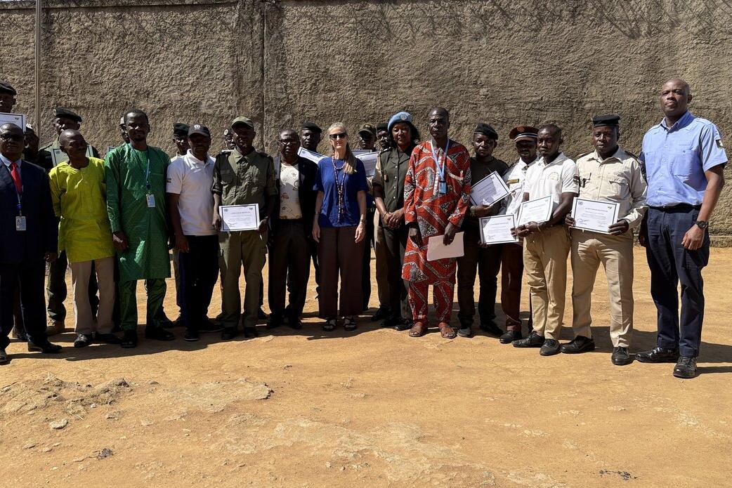Un groupe de personnes se tient en rang, souriant à la caméra