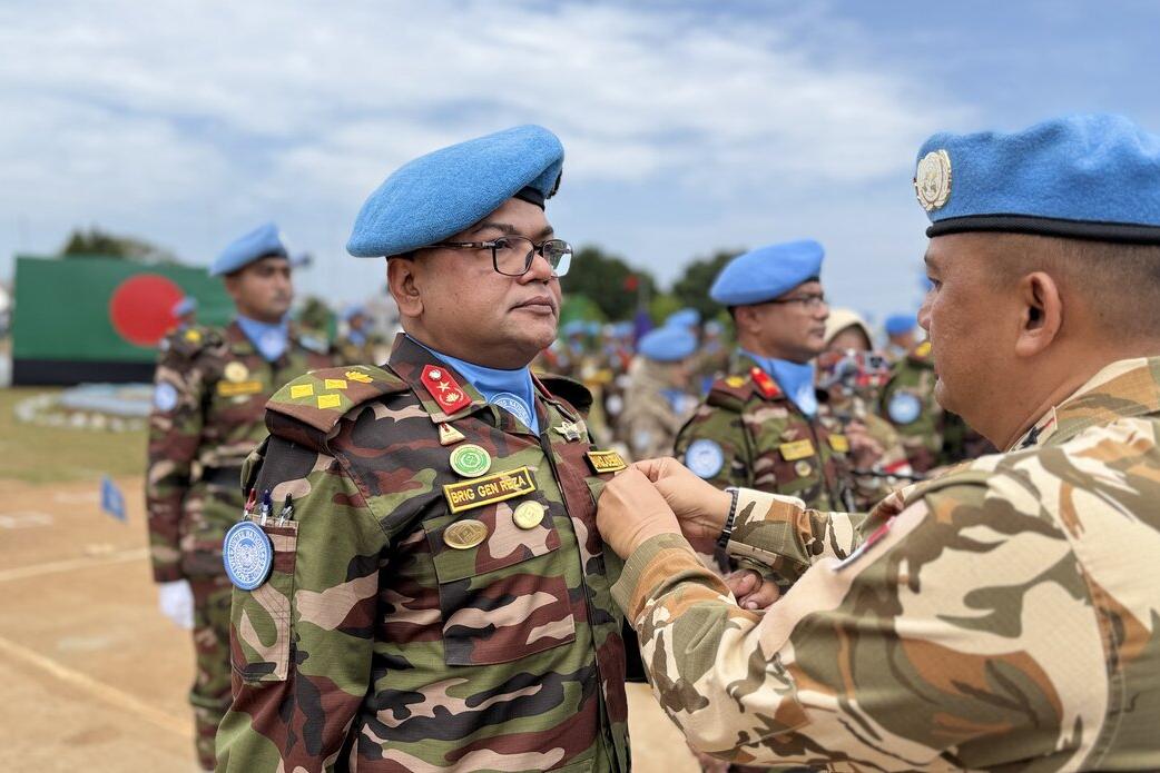 Un casque bleu reçoit une médaille. 