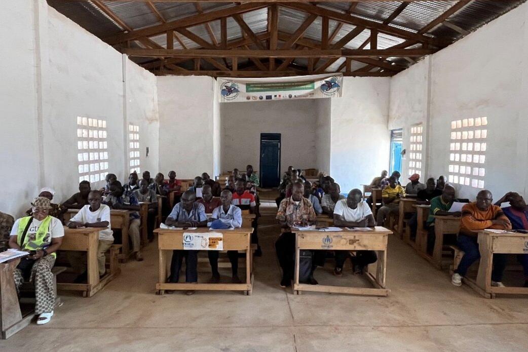 Un groupe de personnes est assis à des bureaux.