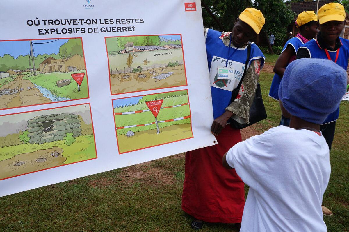 a woman is presenting a poster to a kid