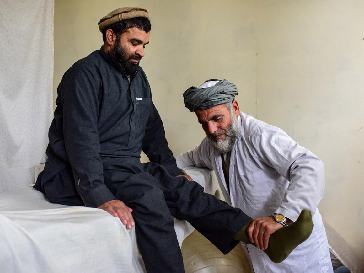 a doctor is giving physical therapy to a male mine victim